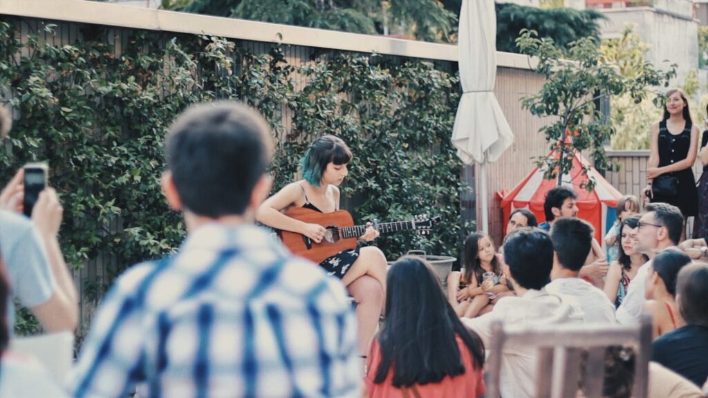 Musicista con chitarra suona su una terrazza