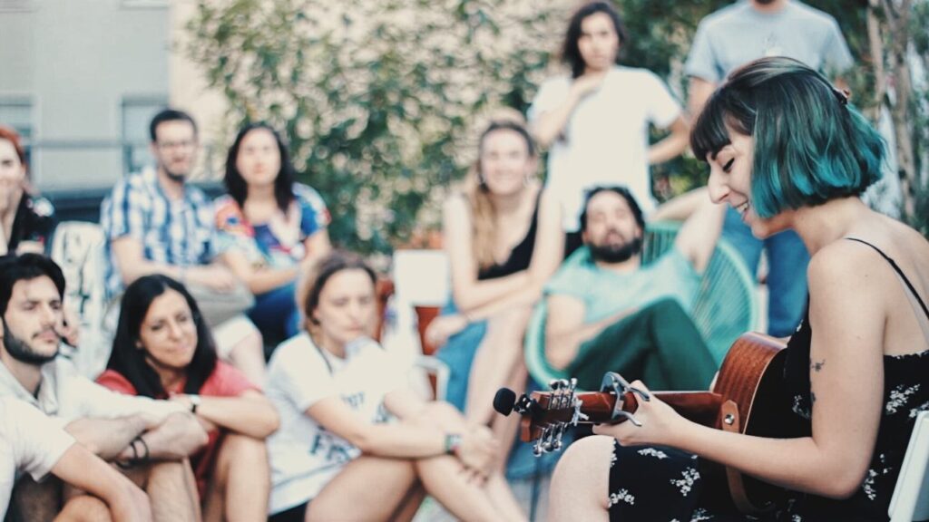 Musicista con chitarra suona davanti a un pubblico